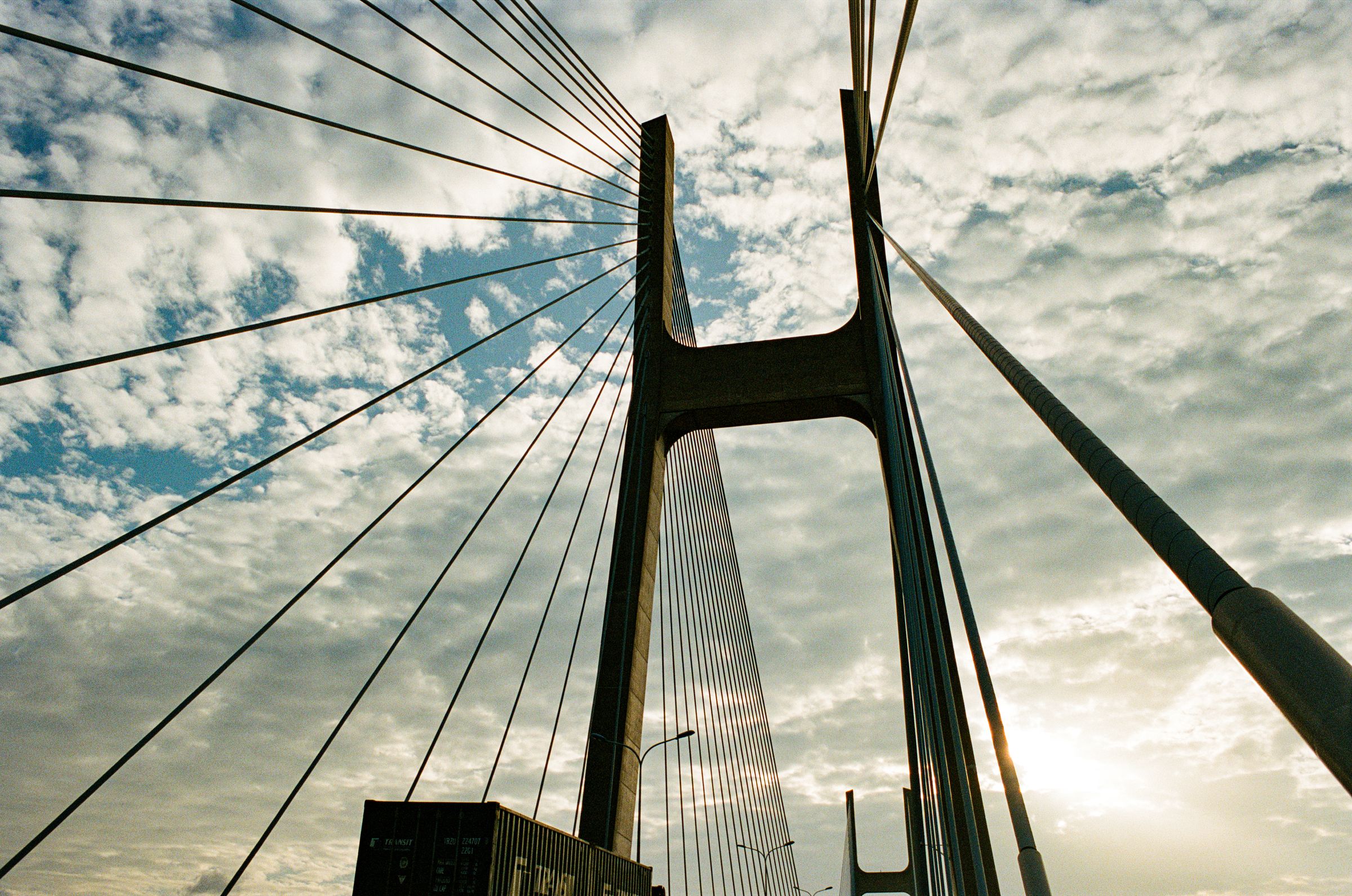 A cable-stayed bridge tower against the sky, shot on film